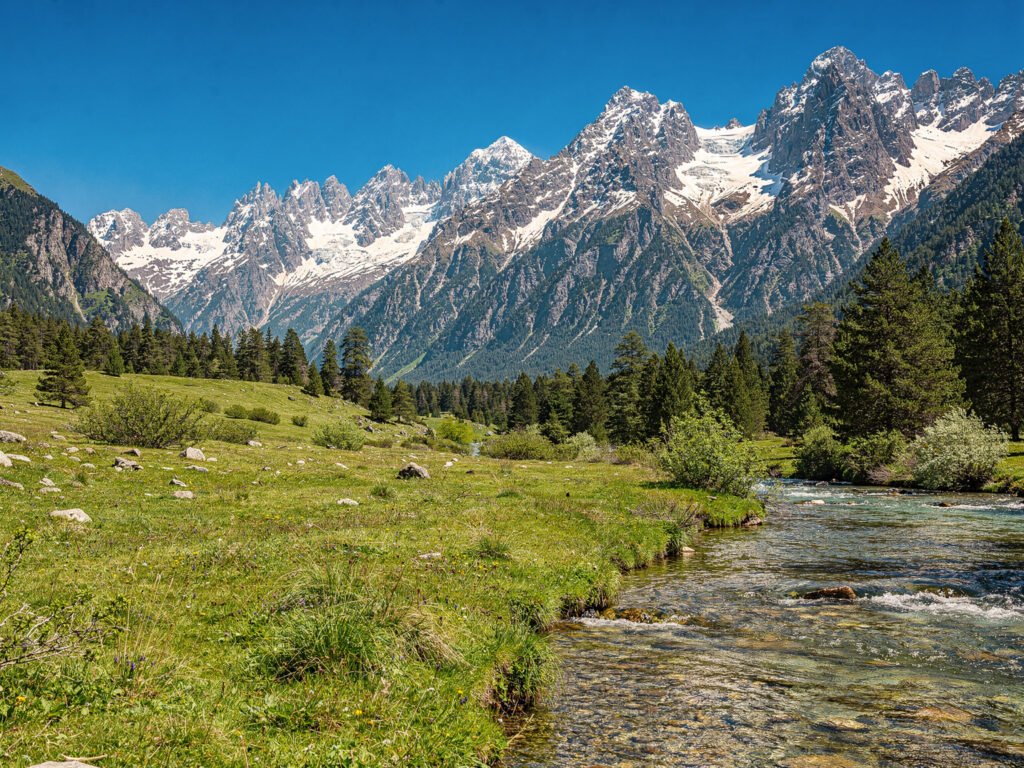 Snow mountains above a green valley (illustrative)